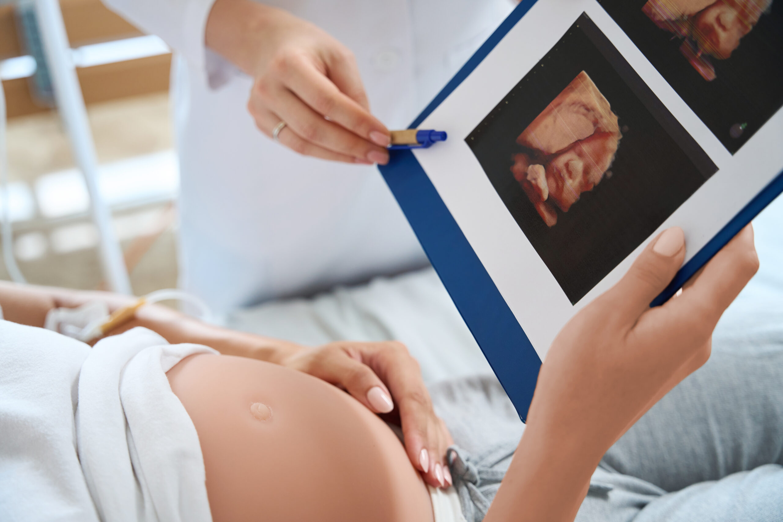 Sonographer showing HD ultrasound portrait photo to pregnant mother in Scotland