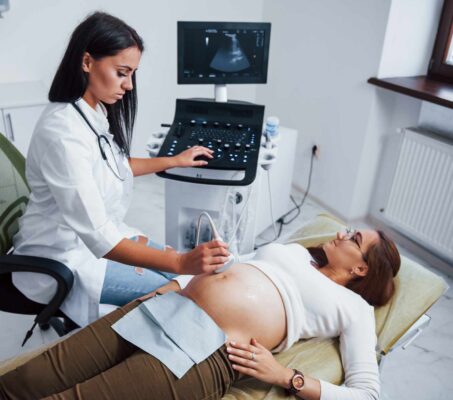 Sonographer explaining GE 5D ultrasound image to parents